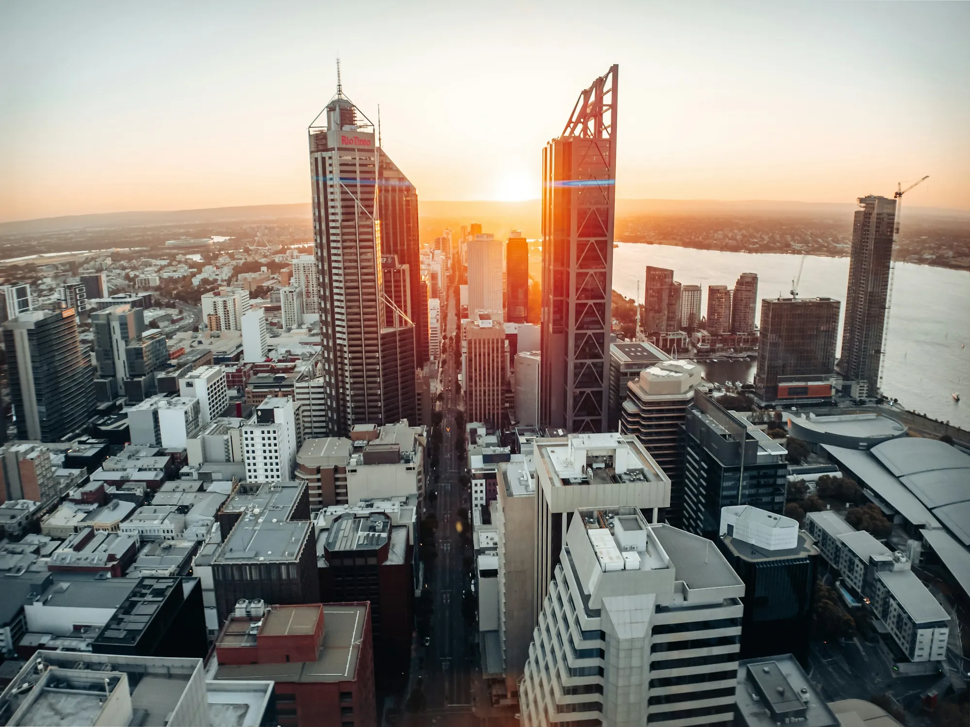 Contemporary commercial building in Perth with glass facade lit warmly at dusk